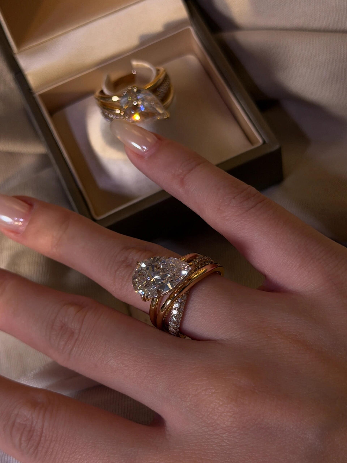 Aurore pear-cut crossover ring worn on the hand