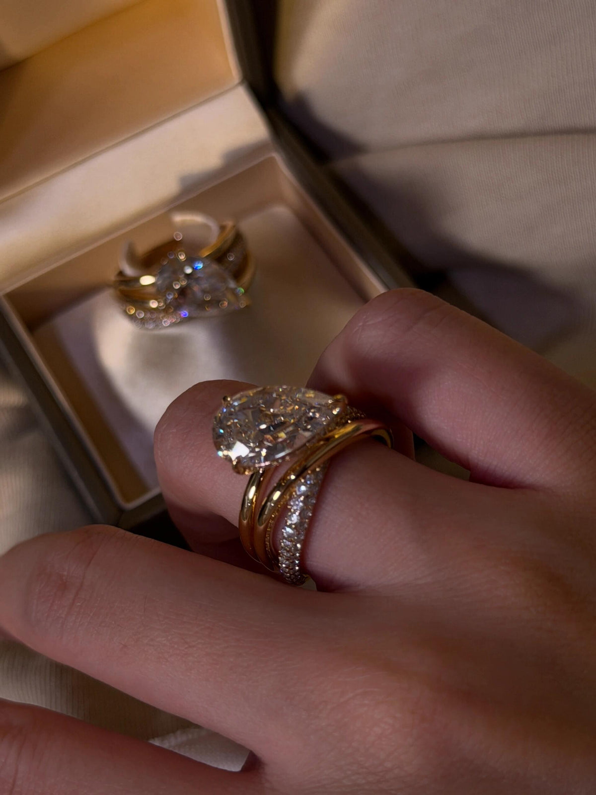 Aurore pear-cut crossover ring worn on the hand