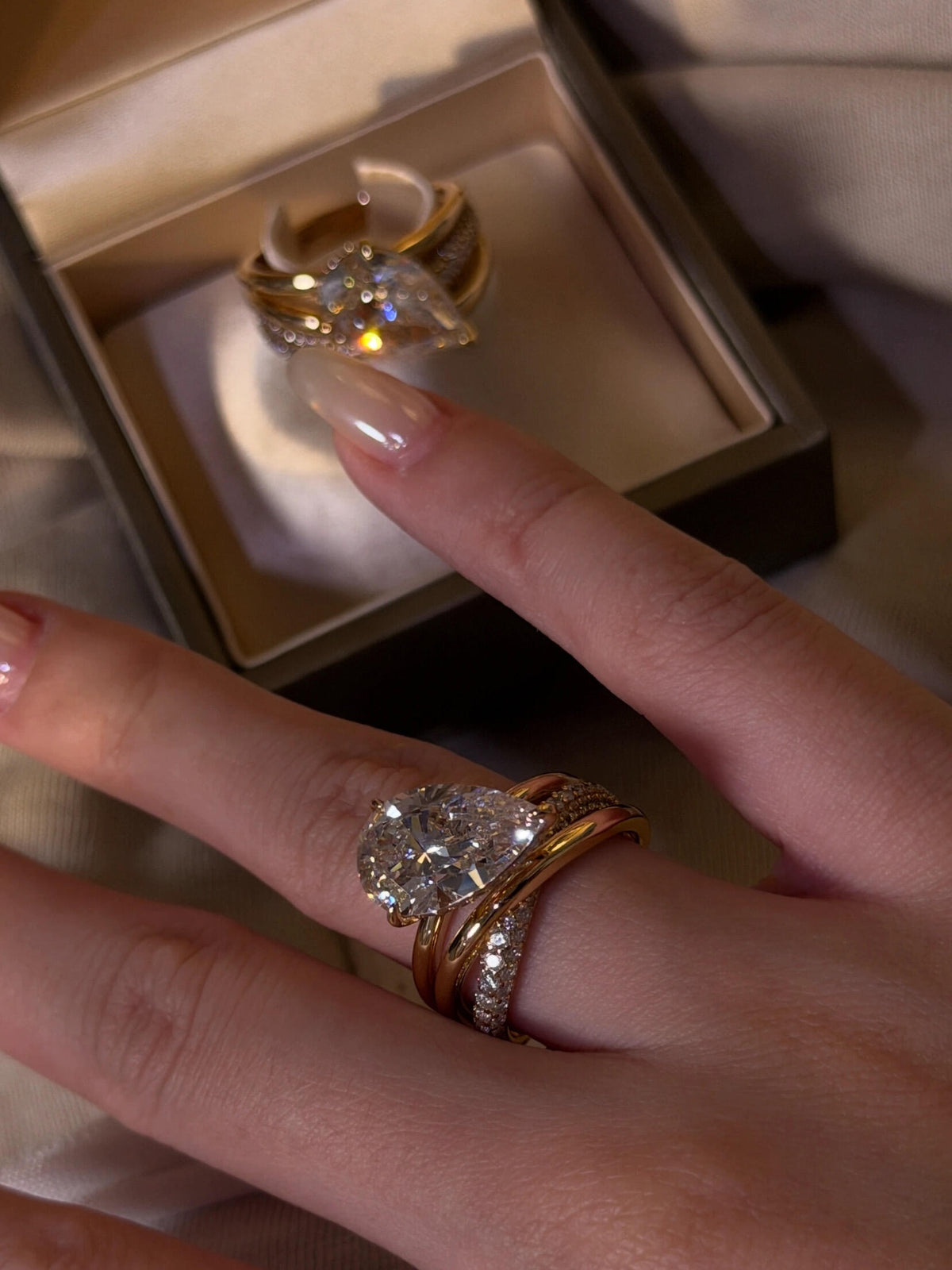 Aurore pear-cut crossover ring worn on the hand